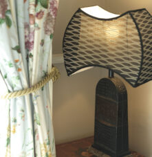 Elegant lamp and floral curtains create a warm, inviting atmosphere in Harveys Guesthouse room.