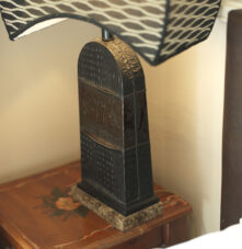 Elegant bedside lamp on a wooden table at Harveys Guesthouse, creating a cosy atmosphere.