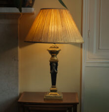 Elegant lamp on wooden table in cosy guesthouse setting.
