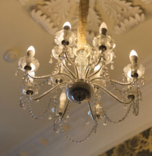 Elegant chandelier with soft lighting creates a cosy, inviting atmosphere at Harveys Guesthouse.