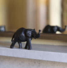 Elegant elephant figurine on a marble mantelpiece, reflecting warmth and charm.