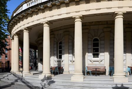 Elegant round building with columns and outdoor seating, inviting for relaxation.