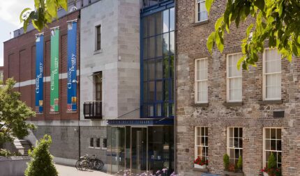 Charming guesthouse exterior with lush greenery and bicycles, inviting atmosphere for families.