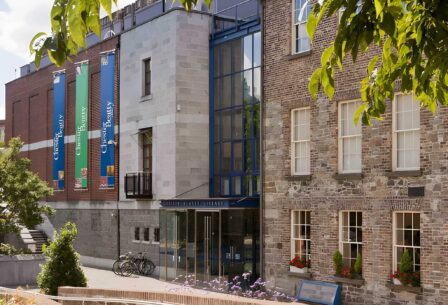 Charming guesthouse exterior with lush greenery and bicycles, inviting atmosphere for families.