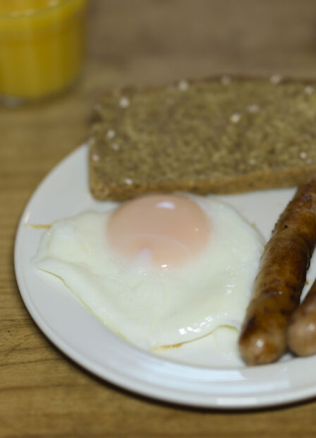 A hearty breakfast with sausages, a fried egg, and toast, perfect for a family morning at Harveys Guesthouse.